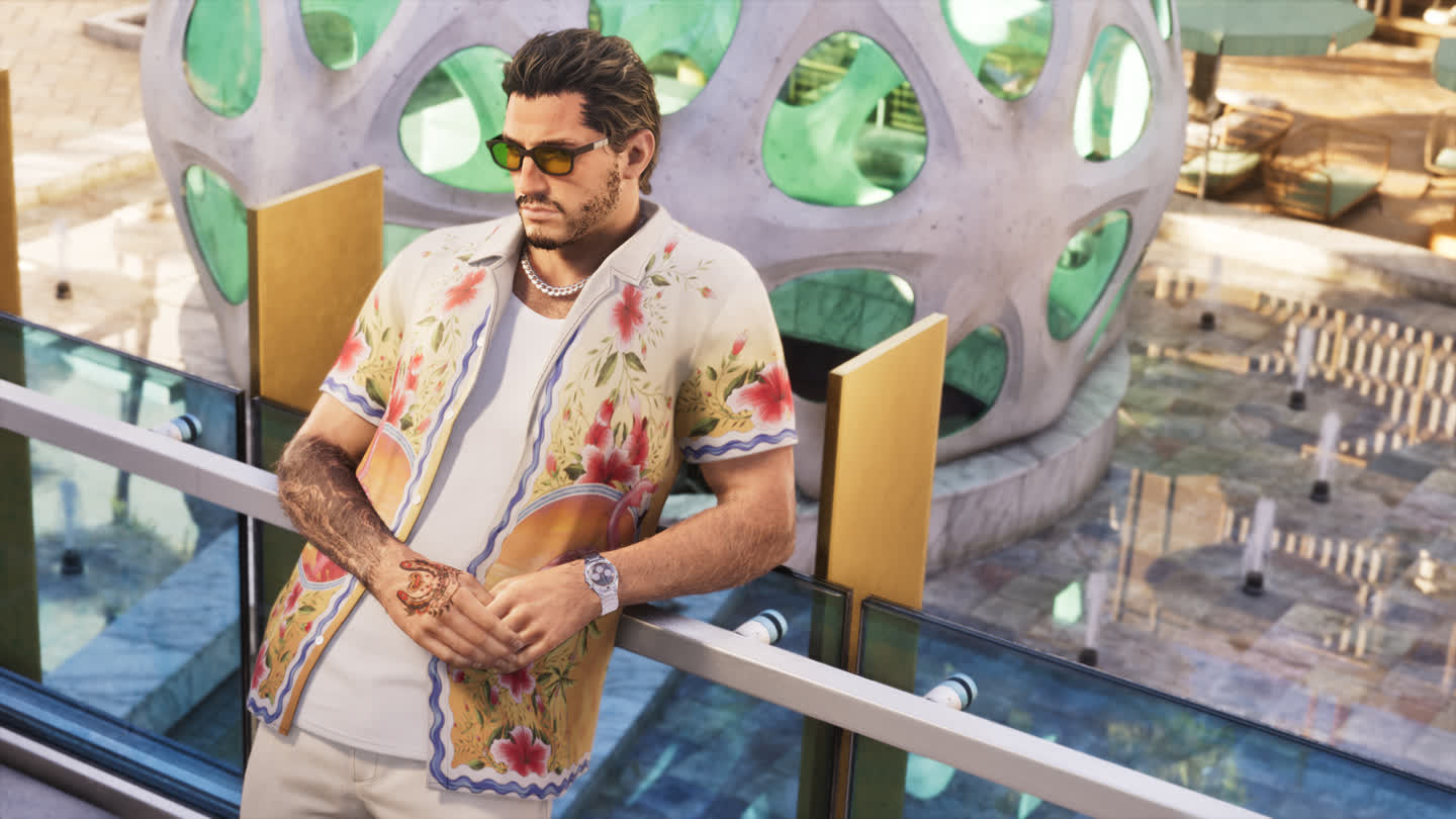 Man in a Colorful Tropical Shirt and Sunglasses Leans on a Glass Railing Outdoors at a Futuristic Rounded Architectural Structure Behind Him